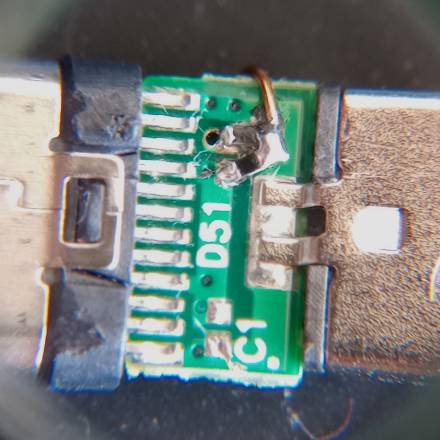 Macro shot of the fixed PCB, showing two SMD resistors at odd angles with a piece of enamelled copper wire coming from their common junction.