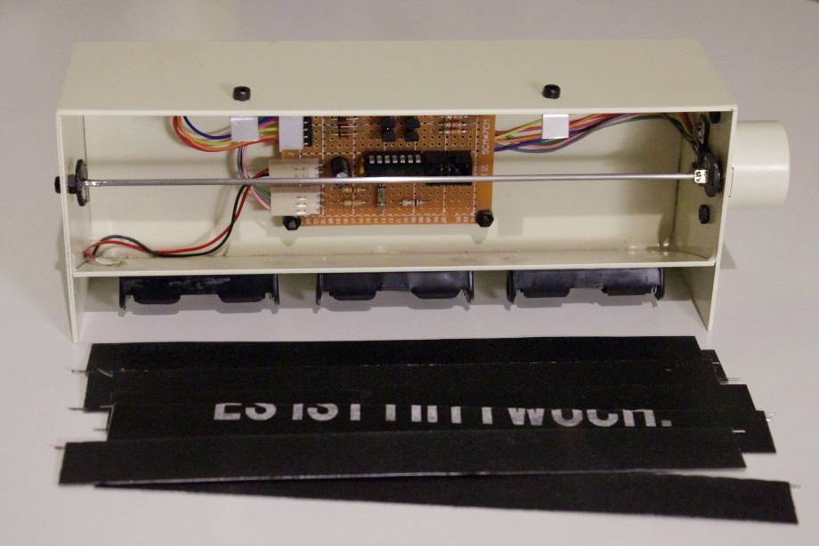 The wide split-flap display, disassembled: the flaps are taken out and lie in front of it. The controller PCB can be seen mounted in the back (it is normally hidden behind the flaps).