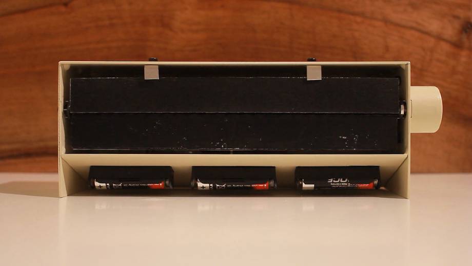 A wide split-flap display, with completely blank, black flaps in an eggshell housing.